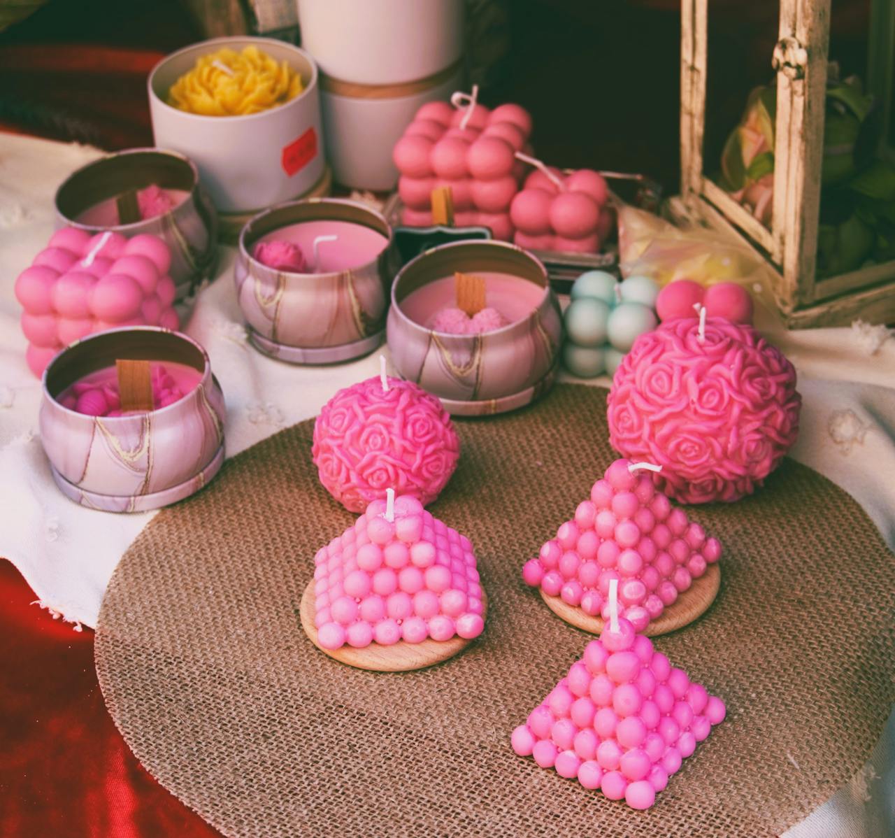 home-hero A selection of vibrant pink handmade candles in various shapes, perfect for home decor.